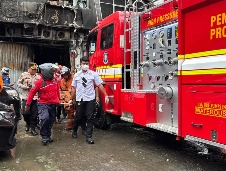 Hình ảnh do Kompas TV phát sóng cho thấy lính cứu hỏa đang nỗ lực tiếp cận tòa nhà để sơ tán người bị mắc kẹt, đồng thời đưa các túi đựng thi thể ra ngoài. Một số nhân viên cũng được thấy thoát xuống từ tầng cao bằng thang di động. (Ảnh: Metro TV)