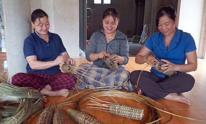 Chị Lý Thị Quý, thôn Khe Ngang (người ngồi giữa) tham gia tổ đan rọ tôm của thôn. (Ảnh: Báo Lào Cai)