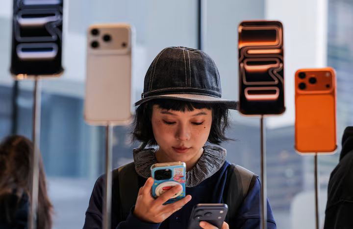 Eine Frau benutzt ihr Handy in einem Apple Store in China während der Markteinführung des iPhone 17. (Quelle: Reuters)