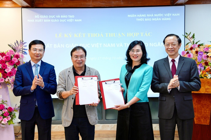 NXB Giáo dục Việt Nam và Thời báo Ngân hàng ký kết văn bản hợp tác dưới sự chứng kiến của Thứ trưởng Bộ GD&ĐT Phạm Ngọc Thưởng (bìa phải) và Phó Thống đốc Ngân hàng Nhà nước Việt Nam Phạm Thanh Hà (bìa trái).