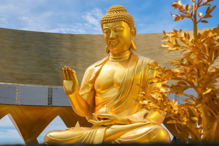 Tôn tượng Phật Câu Na Hàm khuôn mặt từ bi, đôi mắt mở dịu nhìn xuống.