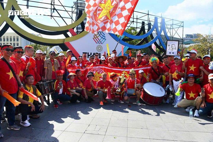 Các cổ động viên chụp ảnh lưu niệm, hát vang các bài hát Việt Nam khiến một góc sân Rajamangala trở nên huyên náo. Nhiều cổ động viên chờ đợi chuyến đi này với khao khát chứng kiến chiến thắng của U22 Việt Nam. Họ vừa kiểm tra ảnh, kiểm tra lại vé vào sân và thông tin trận đấu. Vé môn bóng đá nam có sử dụng hình thức mã QR Code để vào sân.