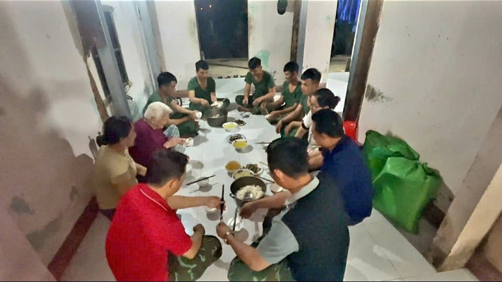Bộ đội cùng người dân quây quần bên mâm cơm tối.