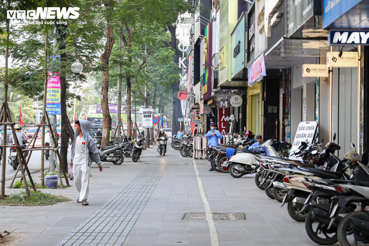 Tại phố Chùa Bộc (phường Kim Liên), các cửa hàng chủ động sắp xếp xe máy dừng đỗ đúng vạch, trả lại không gian vỉa hè rộng rãi cho người đi bộ.