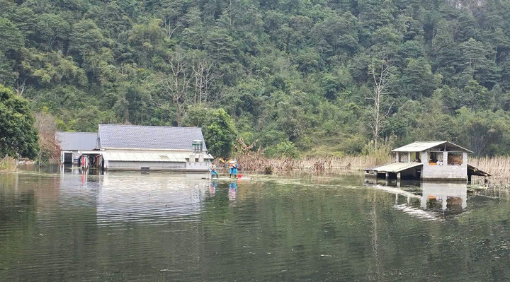 Nhà ngập sâu trong nước, người dân thôn Lũng Phầy phải di chuyển bằng bè tự chế. (Ảnh: X.Đ)