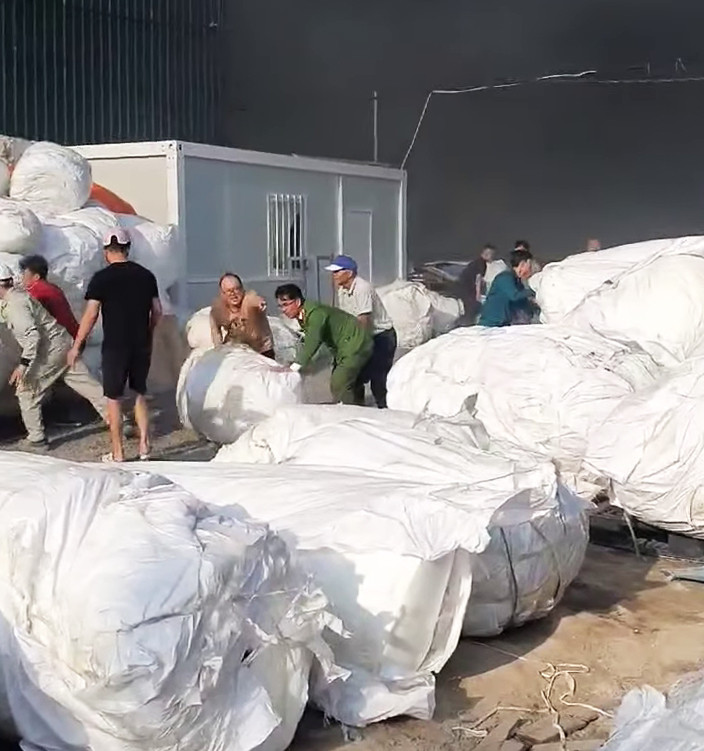 Lực lượng chức năng và công nhân công ty khẩn trương di dời những cuộn nguyên liệu tại khu vực lửa chưa lan tới.