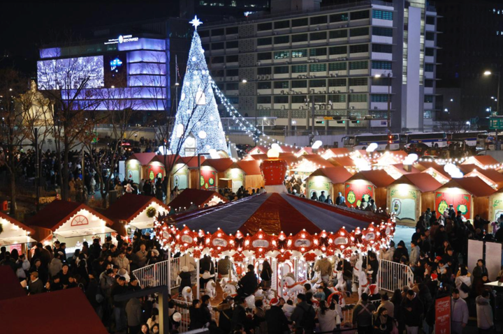 Trong hình là cảnh người dân bắt đầu đổ về chợ Giáng sinh Gwanghwamun tại quảng trường Gwanghwamun ở trung tâm Seoul để cùng nhau tham quan và trải nghiệm các hoạt động dành riêng cho ngày lễ này. (Ảnh: Yonhap)