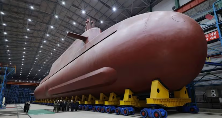 Lãnh đạo Triều Tiên Kim Jong-un và các quan chức bên cạnh tàu ngầm công bố ngày 25/12. (Ảnh: KCNA)