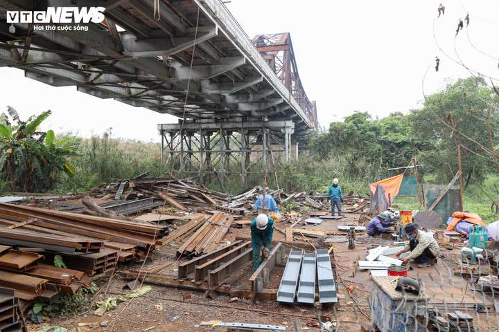 Dưới chân cầu Long Biên, công nhân đang thi công lắp đặt các dầm đỡ chịu lực cho cây cầu.