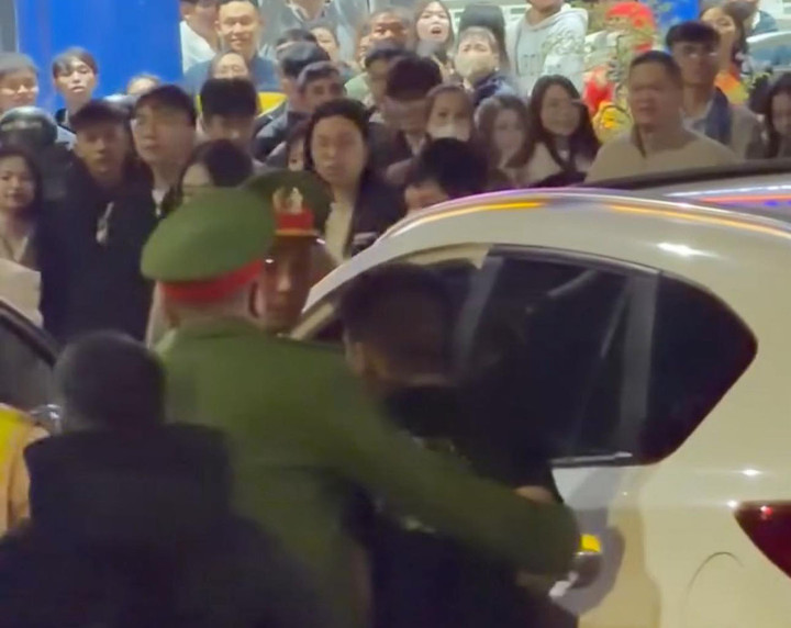 Cảnh sát khống chế một người đàn ông ngồi trong ô tô sau khi xảy ra vụ việc.