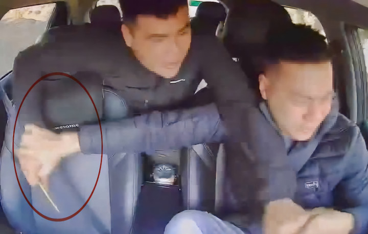 Camera hành trình ghi lại cảnh Khánh dùng đũa tấn công tài xế taxi từ phía sau. ( Ảnh cắt từ clip)