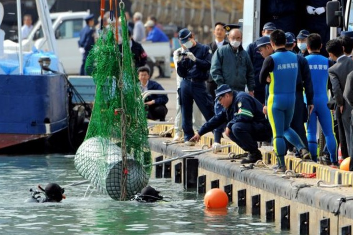 Cảnh sát trục vớt chiếc thùng phuy chứa thi thể của ông Hashimoto. (Nguồn: Asahi Shimbun)