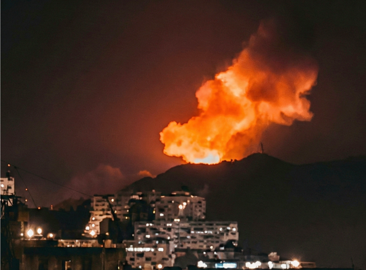 Khói lửa bốc lên sau nhiều vụ nổ lớn tại thủ đô Caracas của Venezuela ngày 3/1 - Ảnh: Reuters