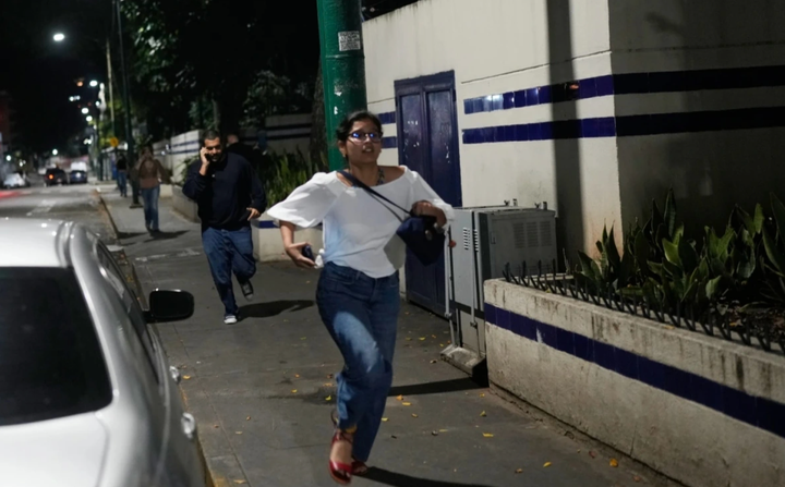 Người dân bỏ chạy sau khi có những tiếng nổ lớn ở thủ đô Caracas của Venezuela vào sáng sớm 3/1. Ảnh: AP.