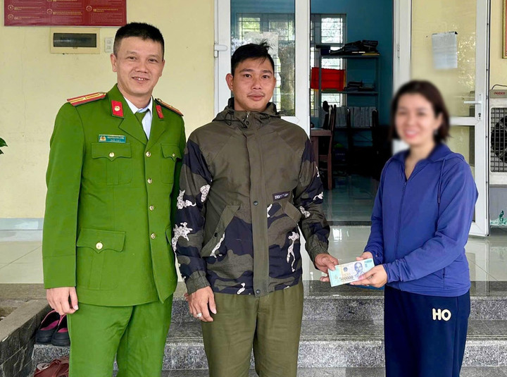 Đại diện Công an phường Vỹ Dạ trao trả lại số tiền 50.000.000 đồng đánh rơi cho chị D. (Ảnh: CA)