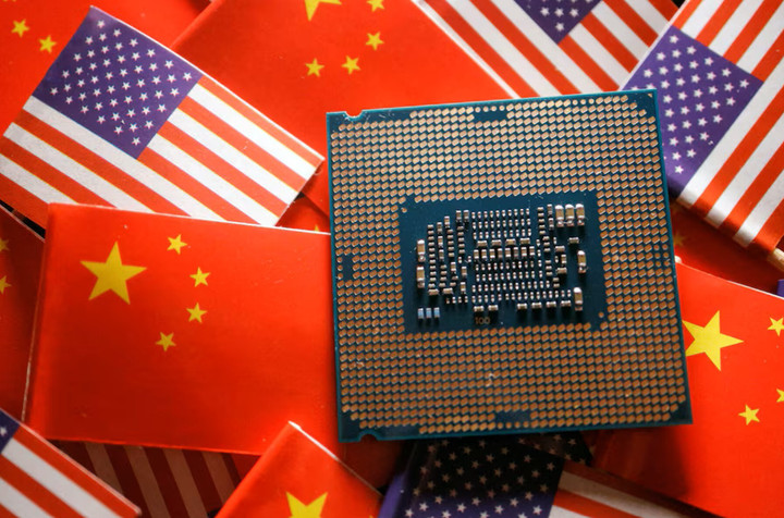Hình ảnh minh họa một chip bán dẫn bộ xử lý trung tâm được trưng bày giữa hai lá cờ của Trung Quốc và Mỹ. (Ảnh: Reuters)