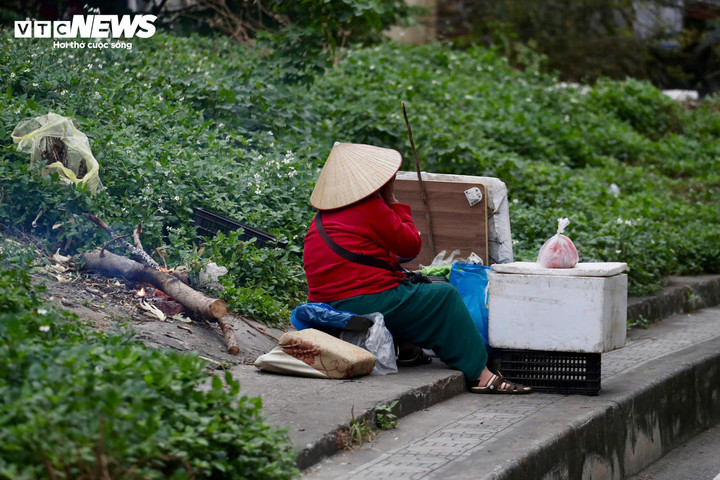 Người phụ nữ bán hàng rong phải nhóm củi, đốt lửa để chống chọi giá lạnh.