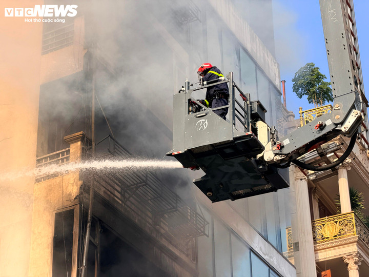 Lực lượng cứu hộ phải phá các ô cửa kính, phá tầng tum để phun nước vào bên trong.