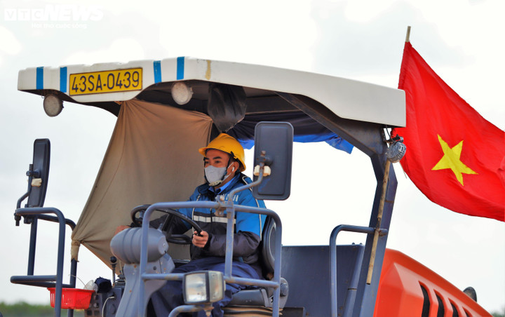 Các máy xúc, xe ben, trạm trộn bê tông hoạt động không ngừng, tiếng động cơ hòa cùng tiếng trao đổi công việc tạo nên một bức tranh lao động nhịp nhàng mà đầy áp lực tiến độ.