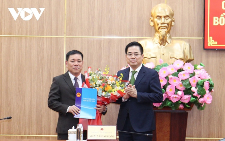 Ông Nguyễn Hoàng Giang, Chủ tịch UBND tỉnh Quảng Ngãi (bên phải) trao quyết định và tặng hoa chúc mừng ông Nguyễn Văn Trọng, Giám đốc Sở Tài chính tỉnh Quảng Ngãi.