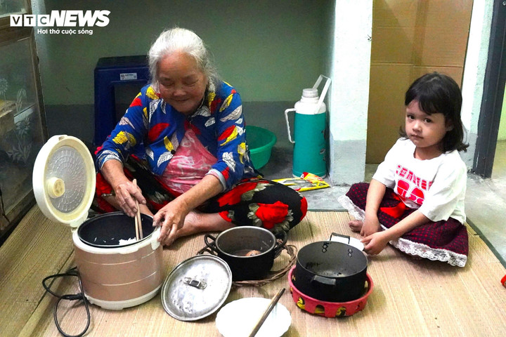 Bà Tài đang dọn cơm cùng cháu nội trong căn nhà do Lữ đoàn pháo binh 572 xây dựng trong "Chiến dịch Quang Trung".