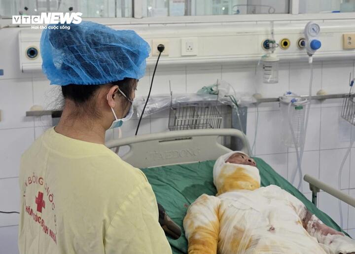 Đứng bên giường bệnh của chồng, chị Năm nhiều lần bật khóc. (Ảnh: Như Loan)