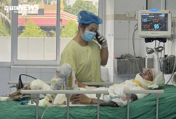 Chị Năm túc trực bên giường bệnh của chồng. (Ảnh: Như Loan)