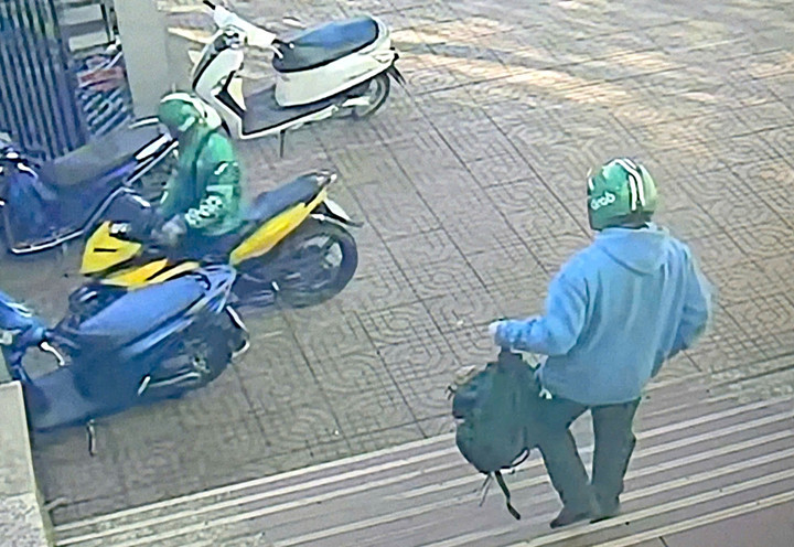 Sau khi cướp ngân hàng, 2 người đàn ông đội mũ có chữ Grab lên xe máy rời khỏi hiện trường