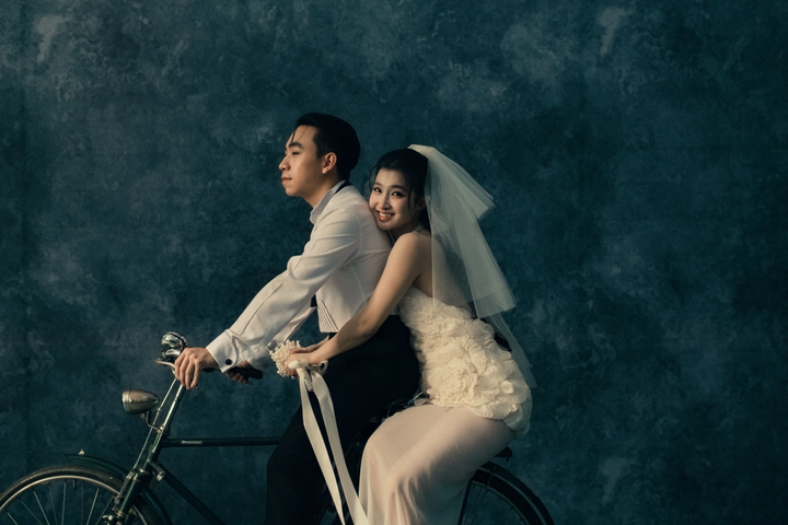 Trong bộ ảnh, cô dâu – chú rể lựa chọn những hình ảnh đời thường, gần gũi. Phương Nhi diện váy cưới đính hoa tinh tế, khoe vẻ đẹp mong manh, trong trẻo. Cả hai cùng ngồi trên chiếc xe đạp mang phong cách cổ điển.