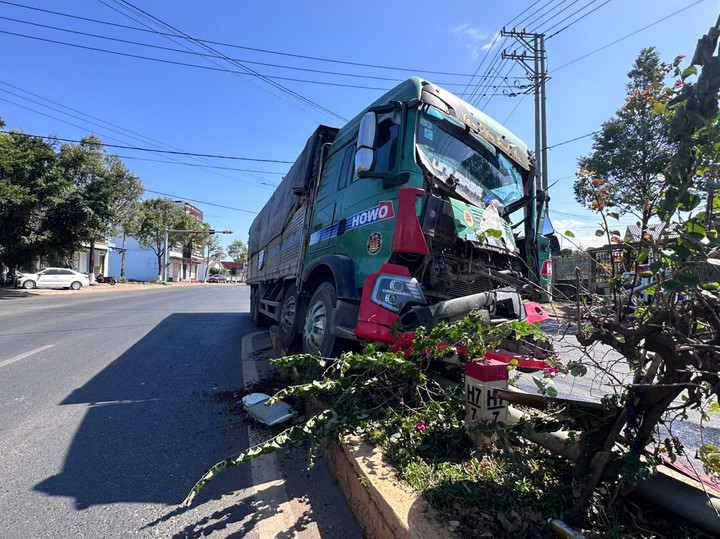 Xe ô tô tải chở vật liệu xây dựng lao lên giải phân cách, hư hỏng đầu xe.