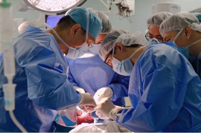 PGS.TS.BS Lê Văn Thành cùng ê-kíp chỉnh lại mảnh gan hiến từ người mẹ trước khi ghép cho bé.