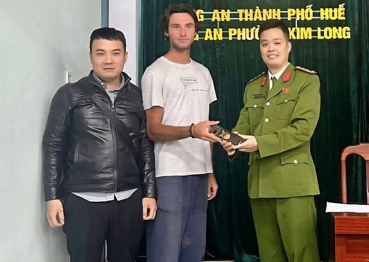 Đại diện Công an phường Kim Long trao trả lại chiếc điện thoại đánh rơi cho ông Clément