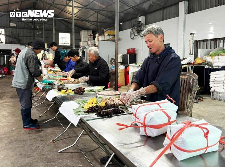 Người dân làng Vũ Đông tất bật gói giò để kịp trả hàng cho khách dịp cao điểm Tết. (Ảnh: Khánh Linh)