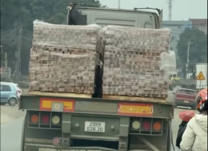 Ô tô chở gạch không chằng buộc, gây nguy hiểm cho người tham gia giao thông ở Hà Nội.