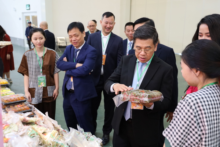 Phó Chủ tịch UBND TP.HCM Nguyễn Văn Dũng giới thiệu món bánh tét - đặc sản Tết phương Nam đến người tiêu dùng phía Bắc.