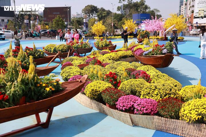 Phía trước cổng chợ trang trí các tiểu cảnh từ những chậu hoa cúc mâm xôi, cành mai, đào mang đậm không khí Tết cổ truyền.