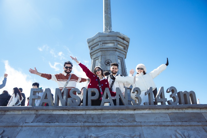 Du khách quốc tế vui vẻ check in đỉnh Fansipan.