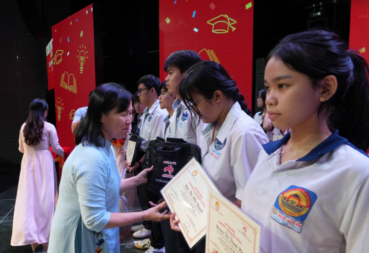 Bà Lê Thị Mỹ Phượng - Chủ tịch Hội khuyến học tỉnh Đồng Nai - trao học bổng và quà tặng cặp sách cho các em học sinh.