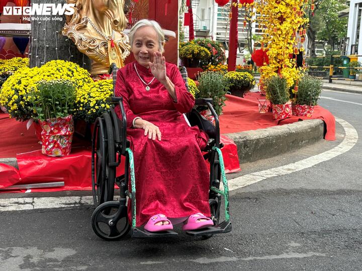 Cụ Đặng Thị Ca (89 tuổi, ngụ tỉnh Quảng Ngãi) đang điều trị u phổi, khoác lên mình chiếc áo dài đỏ, ghi lại khoảnh khắc ngập tràn sắc xuân những ngày cuối năm.