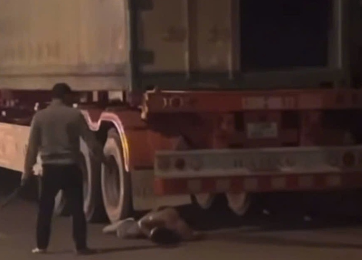 Người đàn ông dùng hung khí đánh gục người khác ngay cạnh xe container. (Ảnh cắt từ clip)
