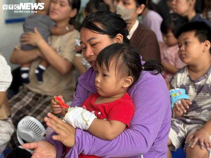Bệnh nhân nhi được người thân bế xuống khuôn viên tham gia chương trình của bệnh viện.