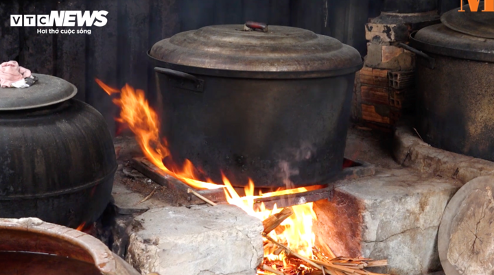 Người làm bánh vừa gói bánh vừa canh lửa cho nhiều nồi bánh cùng lúc, công việc đòi hỏi sự tỉ mỉ và kinh nghiệm lâu năm.