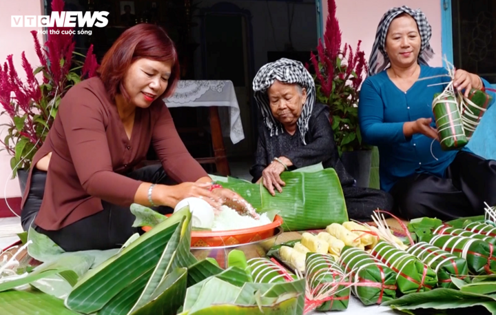 Bà Nguyễn Thị Ích (ở giữa) hướng dẫn con cháu gói bánh tét.