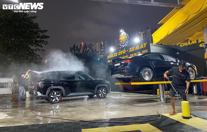 Tiệm rửa xe trên đường Cách Mạng Tháng Tám làm việc đến đêm. (Ảnh: Đại Việt)