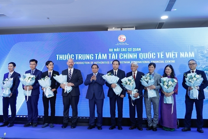 Thủ tướng tặng hoa cho đại diện các cơ quan thuộc Trung tâm Tài chính quốc tế Việt Nam. (Ảnh: VGP)