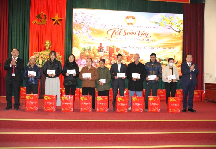 Ông Phan Văn Sự Bí thư Đảng ủy xã Phúc Sơn (bên trái) trao quà cho các gia đình chính sách, hộ có hoàn cảnh đặc biệt khó khăn.