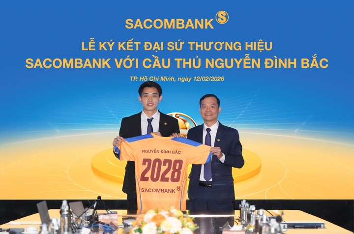Ông Hà Văn Trung - Phó Tổng Giám đốc thường trực SACOMBANK - trao trang phục cho Đại sứ thương hiệu Nguyễn Đình Bắc tại buổi lễ ký kết.