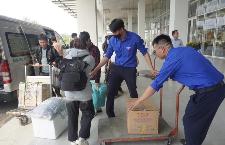 Hành khách được đoàn thanh niên bến xe hỗ trợ vận chuyển hành lý.