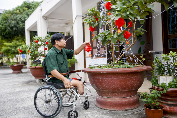 Bác Nguyễn Công Thắng – cựu chiến binh đang được chăm sóc tại Trung tâm Điều dưỡng Thương binh và Người có công Long Đất – chăm chút cho góc Tết trước phòng ở. (Ảnh: Minh Anh).