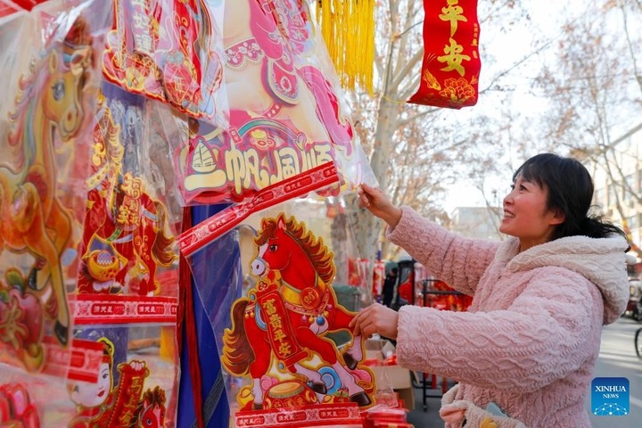 Người phụ nữ mua sắm đồ trang trí Tết tại huyện Vũ Trị, tỉnh Hà Nam, miền trung Trung Quốc.